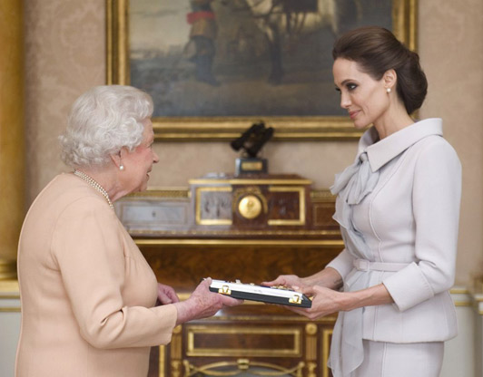 Jolie is presented with the insignia of an Honorary Dame Grand Cross of the Most Distinguished Order of St Michael and St George by The Queen
